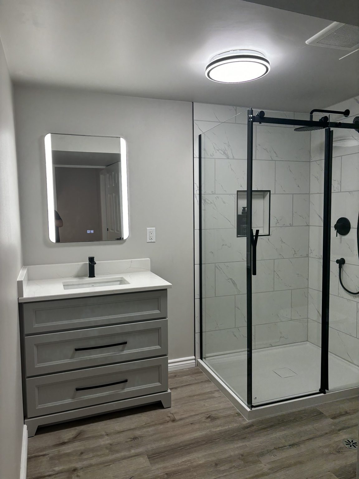 Finished bathroom renovation with vanity and glass shower